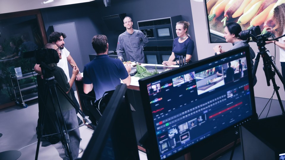 A full production crew surrounds the Miele kitchen set during a live cooking segment