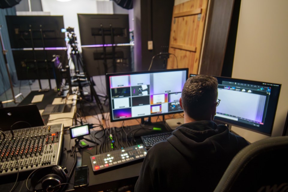 Rear view of adult man TV editor working in television studio